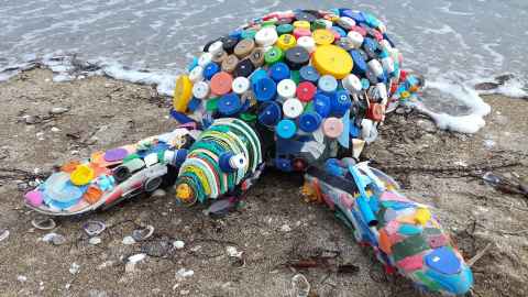 A turtle made out of pieces of multi-coloured recycled plastic. 