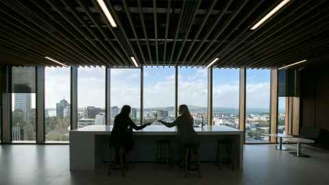 women in silhouette in the the science building with a view over Auckland
